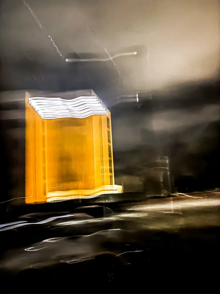 Caja de luz: fotografía artística de forma ámbar luminosa sobre fondo oscuro en movimiento, serie Color y forma, por Robert Díaz