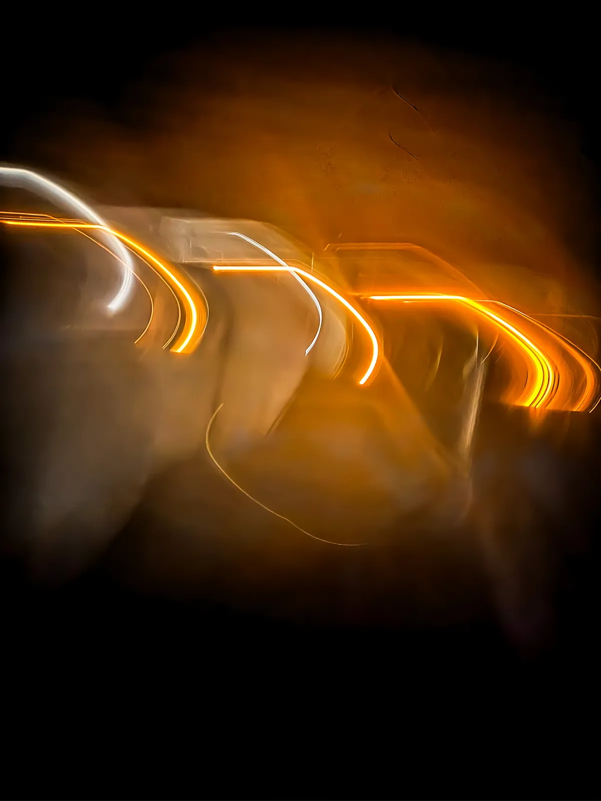 Ámbar: fotografía abstracta de luz en movimiento en tonos naranja y amarillo sobre fondo oscuro, serie Luz en movimiento, por Robert Díaz