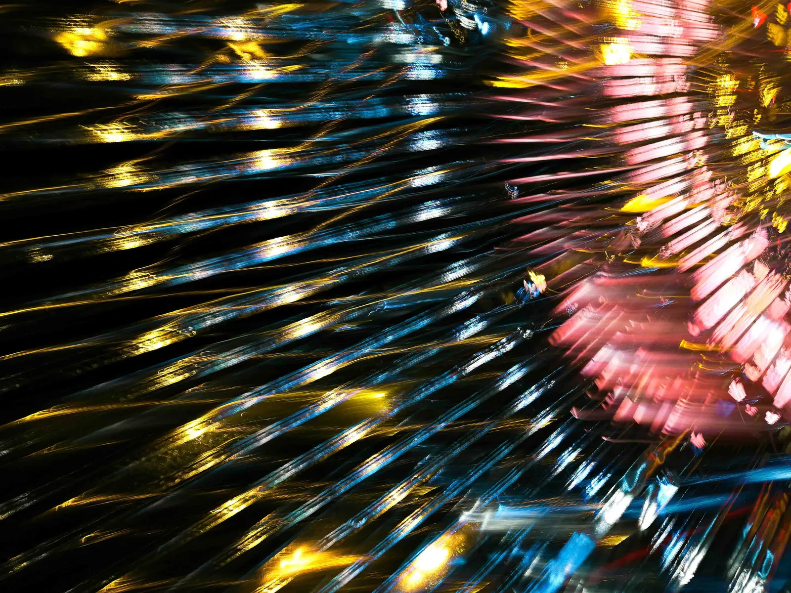 Caleidoscopio: fotografía abstracta de luz en movimiento en tonos amarillo y rojo sobre fondo oscuro, serie Luz en movimiento, por Robert Díaz