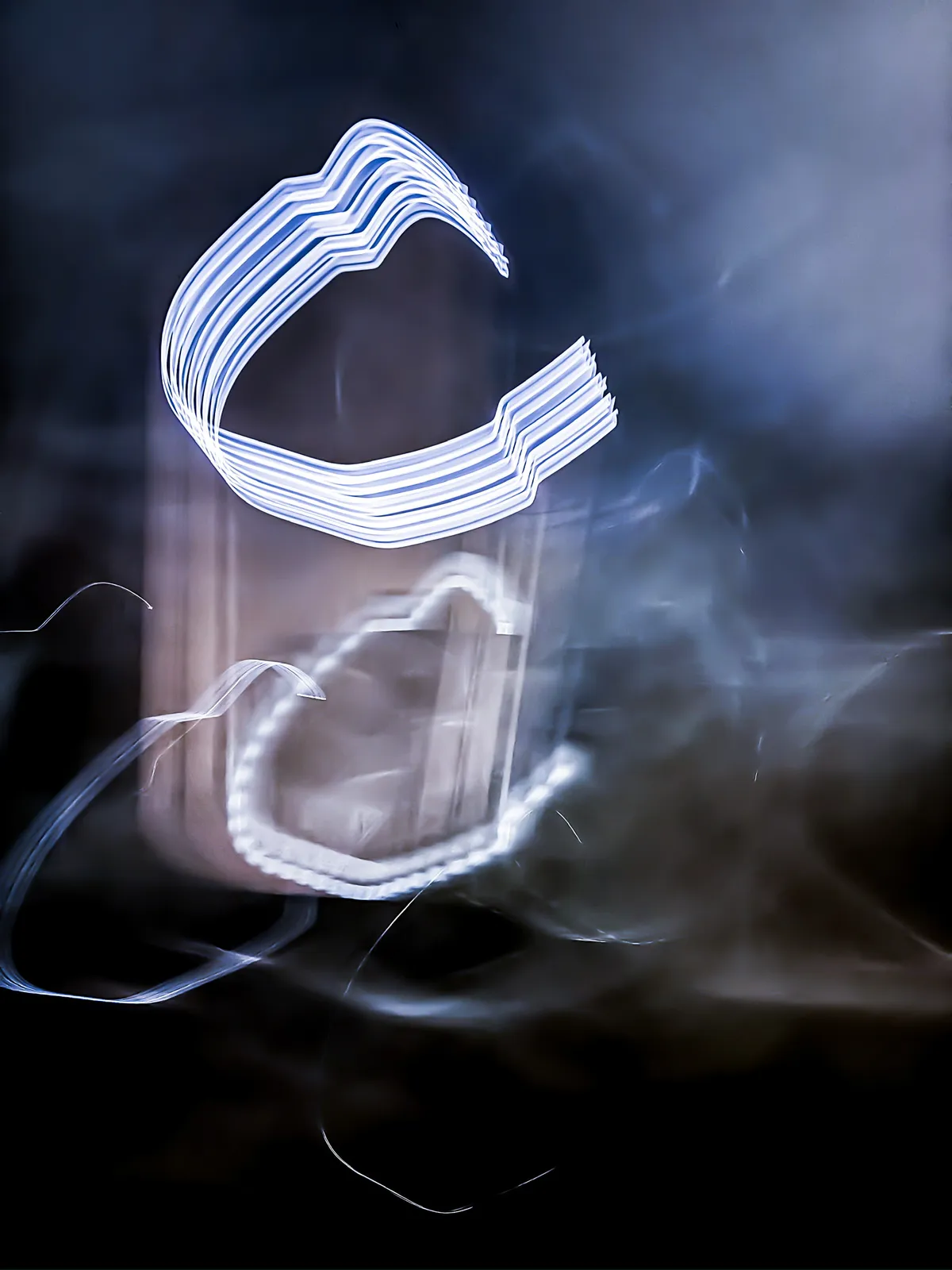 Fantasma de neón: fotografía abstracta de luz en movimiento en tonos azul y violeta sobre fondo oscuro, serie Luz en movimiento, por Robert Díaz