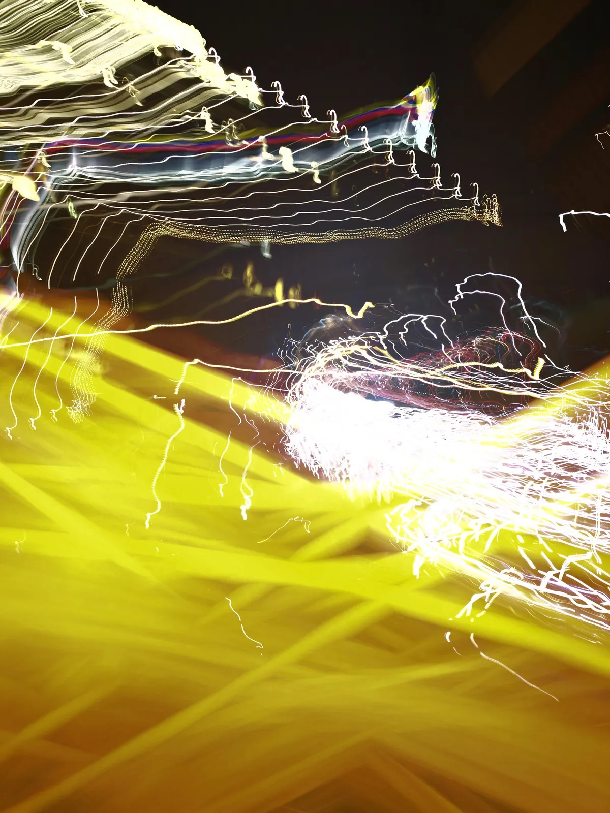 Fulgor amarillo: fotografía abstracta de luz en movimiento en tonos amarillo y naranja sobre fondo oscuro, serie Luz en movimiento, por Robert Díaz