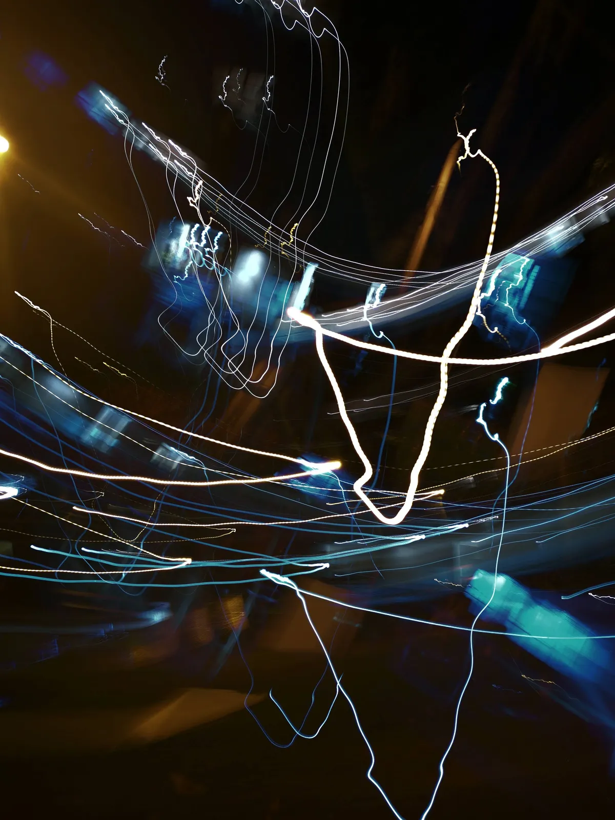 Hilo blanco: fotografía abstracta de luz en movimiento en tonos naranja y azul sobre fondo oscuro, serie Luz en movimiento, por Robert Díaz