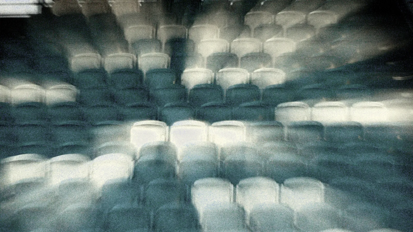 Patio de butacas: fotografía abstracta de luz en movimiento en tonos turquesa y verde sobre fondo oscuro, serie Luz en movimiento, por Robert Díaz