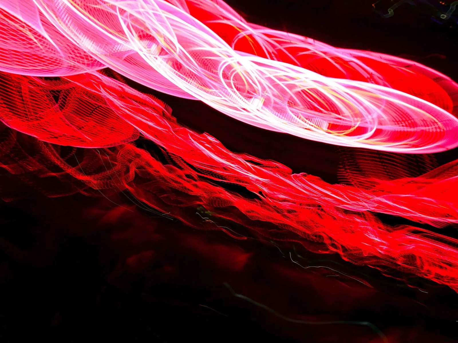 Seda roja: fotografía abstracta de luz en movimiento en tonos rojo y magenta sobre fondo oscuro, serie Luz en movimiento, por Robert Díaz