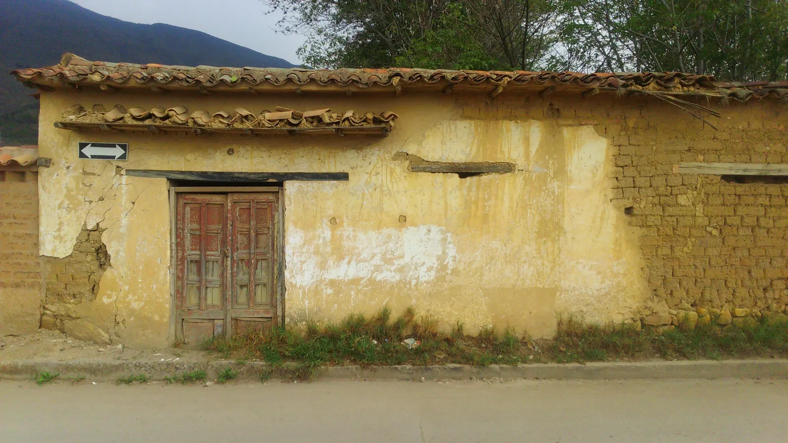 Casa amarilla y puerta roja: fotografía artística de puerta o ventana antigua en muro de pueblo, serie Puertas y muros, por Robert Díaz