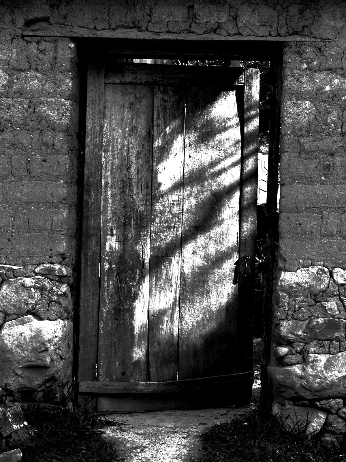 Puerta en blanco y negro: fotografía artística de puerta o ventana antigua en muro de pueblo, serie Puertas y muros, por Robert Díaz