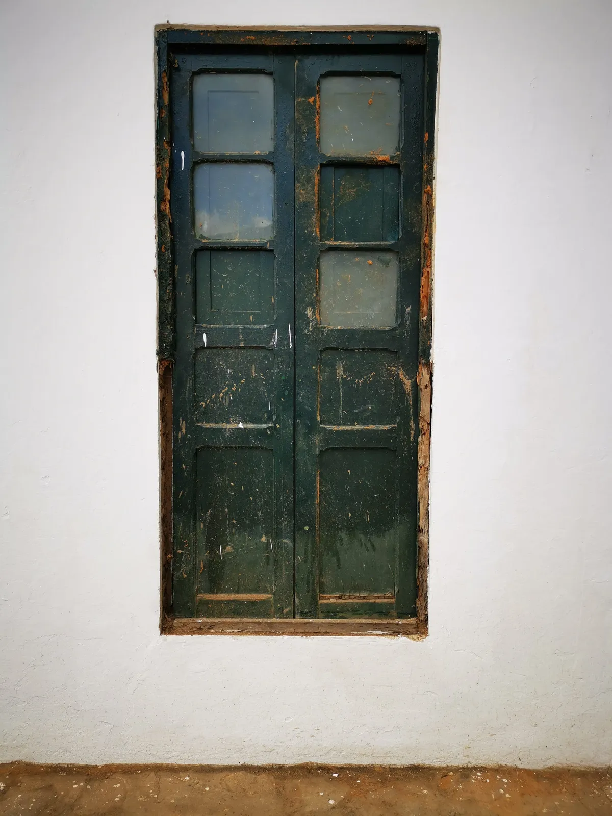 Ventanal oscuro en muro blanco: fotografía artística de puerta o ventana antigua en muro de pueblo, serie Puertas y muros, por Robert Díaz